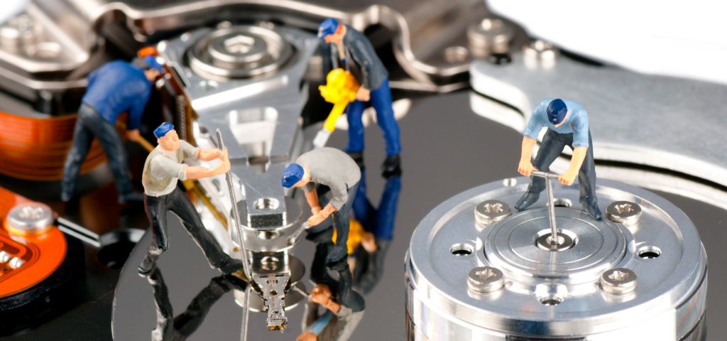 Group of construction workers repairing hard disk drive